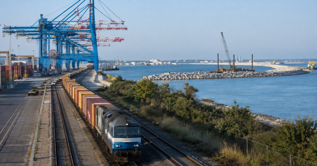 Terminal portuaria europea con tren de carga y rompeolas en construcción