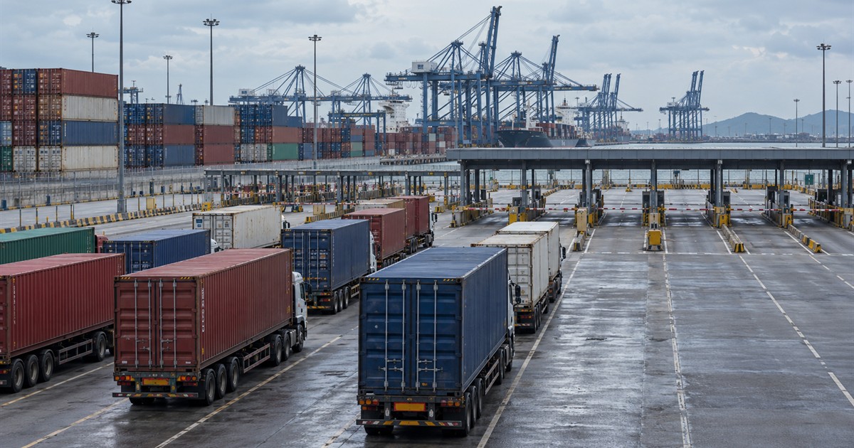 Camiones y contenedores en los accesos de una terminal portuaria asiática